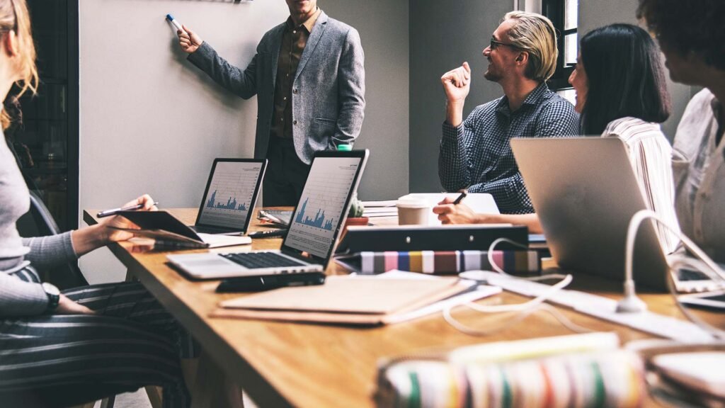 Esta imagen podría representar la importancia del inglés empresarial en la comunicación entre colegas durante reuniones y discusiones de trabajo